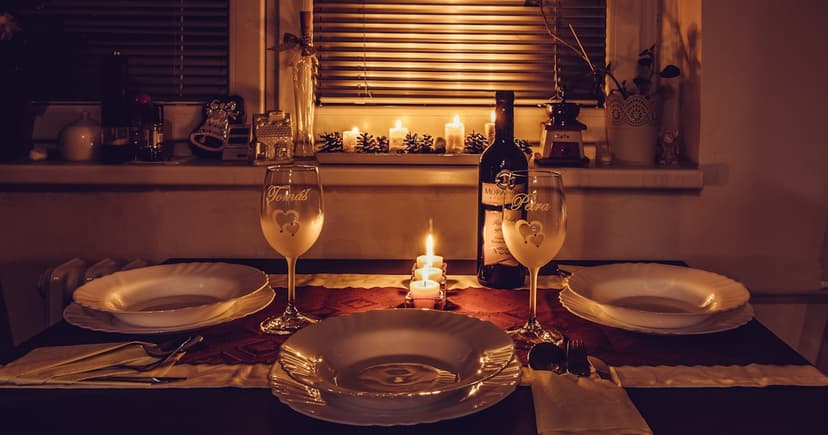 three sets of plates, two wine glasses, and bottle of wine on table