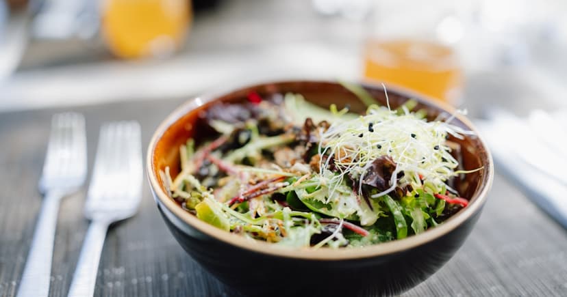 A fresh salad in a bowl on a wooden table.